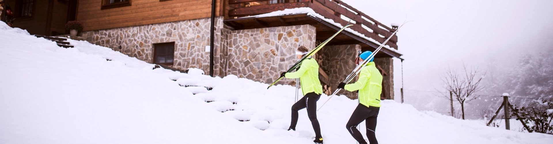 senior couple hiking through the snow with their skis